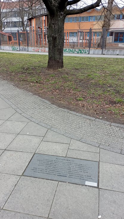 Eine Bodentafel erinnert an die Pflanzung der Friedrichshainer Friedenseiche im Oktober 1990 an der Ecke Persiusstraße/ Corinthstraße